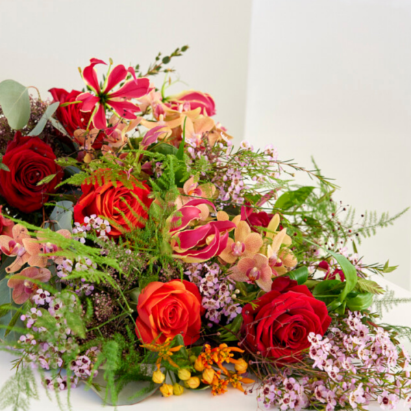 Rouwboeket in warme rood tinten van seizoensbloemen